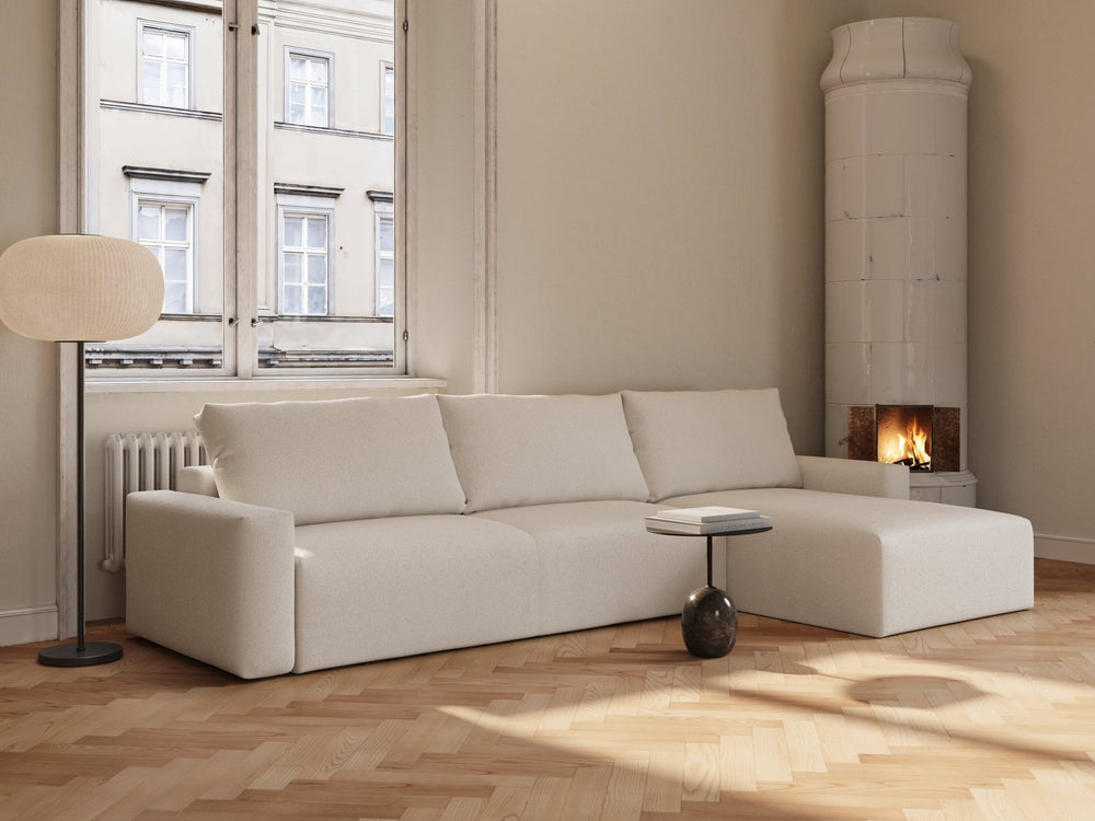 Off-white bouclé sovesofa Maru 145x342 cm, hjørneløsning med lave armlener, tre puter i lys stue foran peis