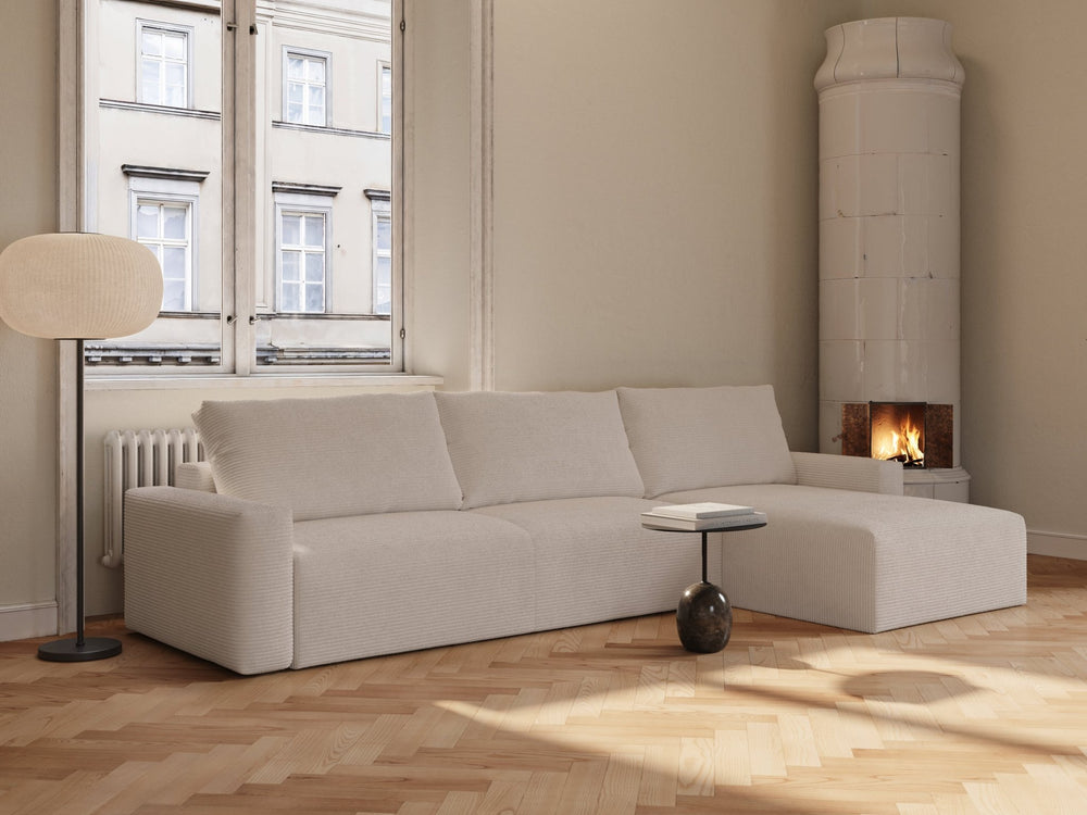 Ivory sovesofa Maru 145x342 cm i ribbet kremfarget stoff, L-formet med løs ryggpute i lyst minimalstisk rom under vindu.