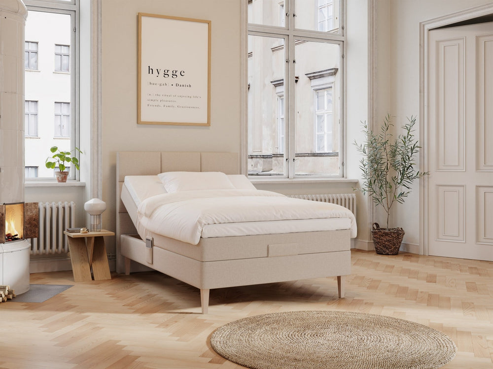 Regulerbar seng Ragna 120x200 i sandfarget stoff, opphøyet hodeende, hvitt sengetøy i lyst, hygge-inspirert soverom