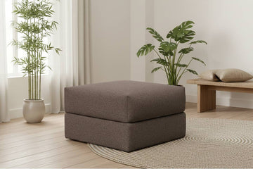 Kvadratisk puf 75x75 i forest brown, brun tekstiltrekk, myk form med to lag, plassert på rund teppe i lyst rom